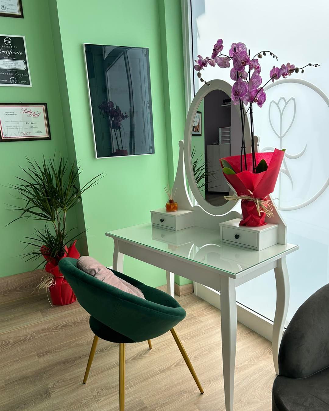 Un mobiletto con specchio e fiori in una stanza.