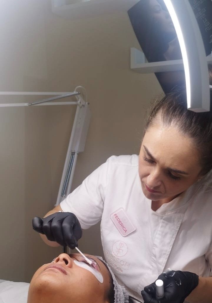 Una donna sta applicando delle extension alle ciglia di una donna.