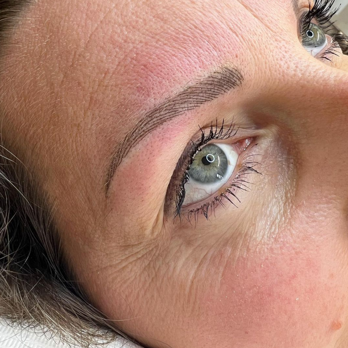 Eine Nahaufnahme des Auges einer Frau mit langen Wimpern.