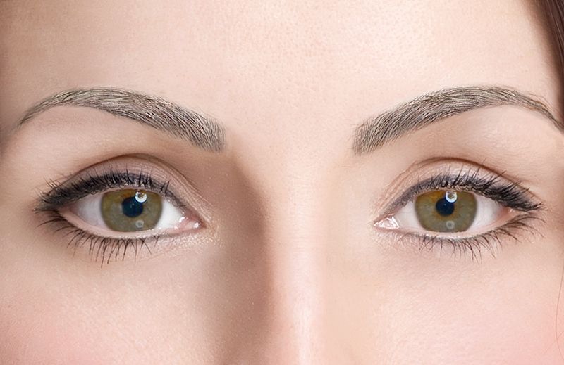 Eine Nahaufnahme der grünen Augen und Augenbrauen einer Frau.