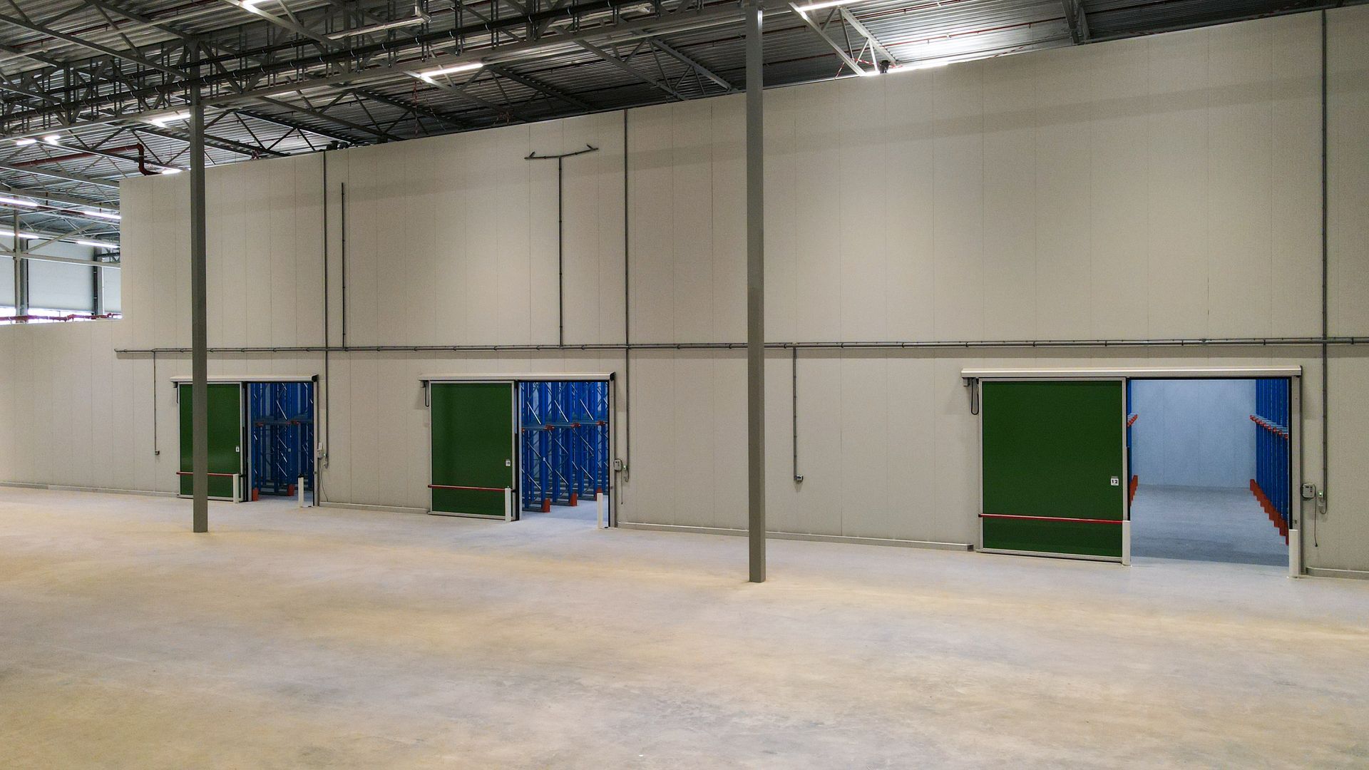 Een groot leeg pakhuis met veel open deuren.