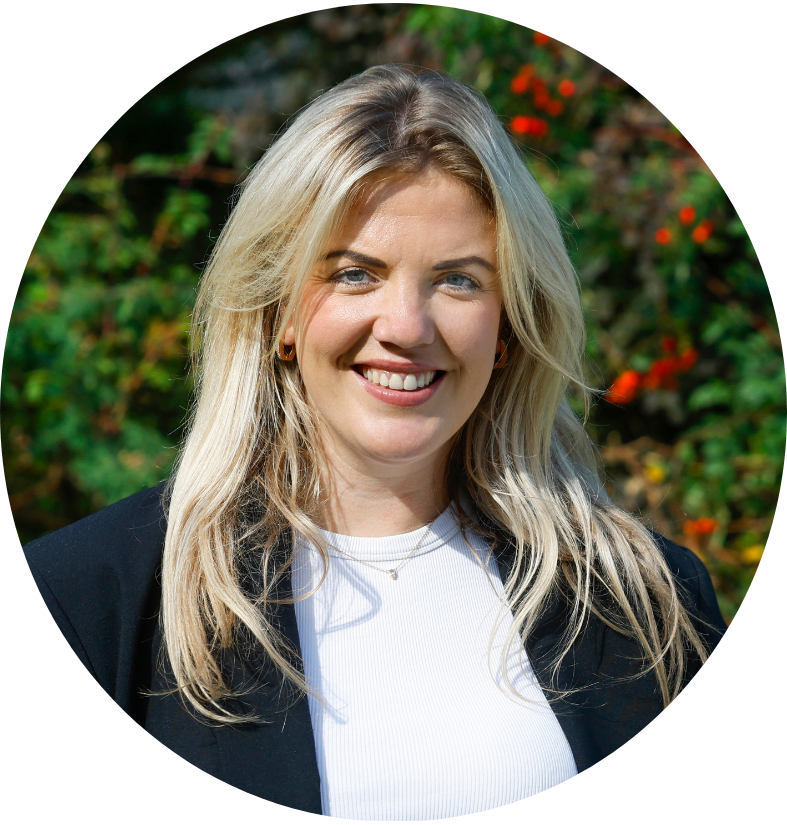 Een vrouw die lacht, ze staat voor een heg