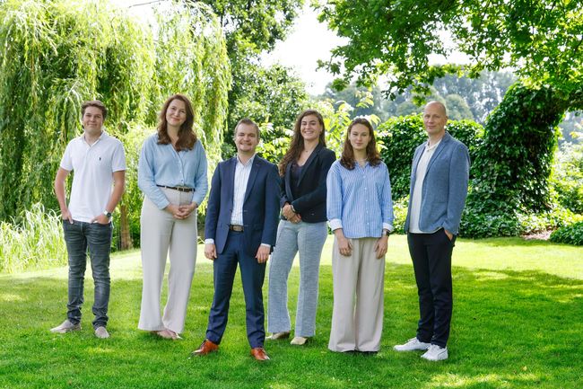 Een groep mensen poseert voor een foto in een park.