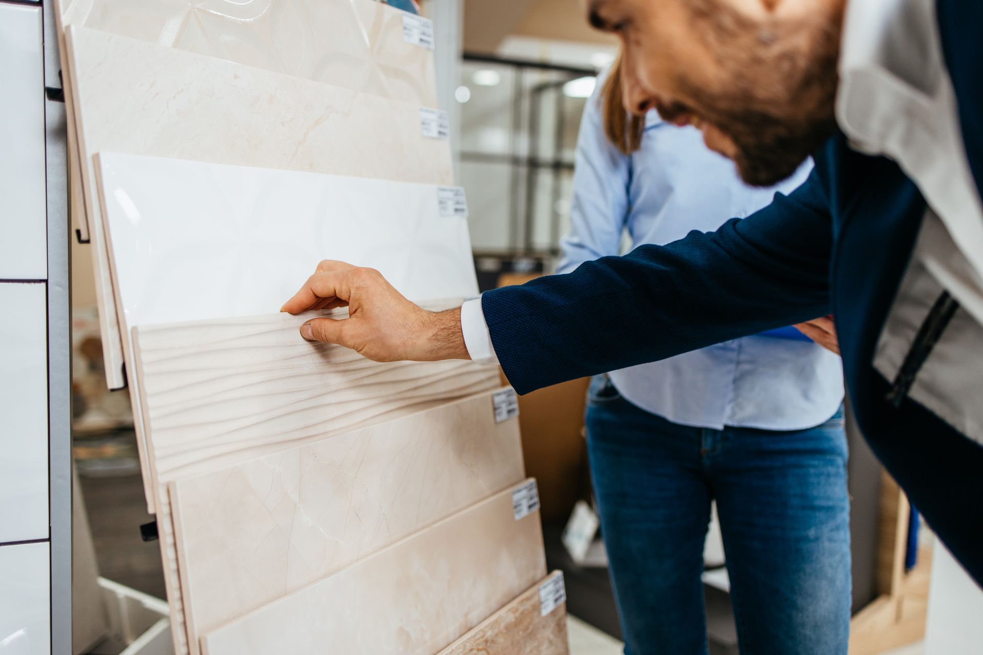 Un uomo e una donna stanno guardando delle piastrelle in un negozio.