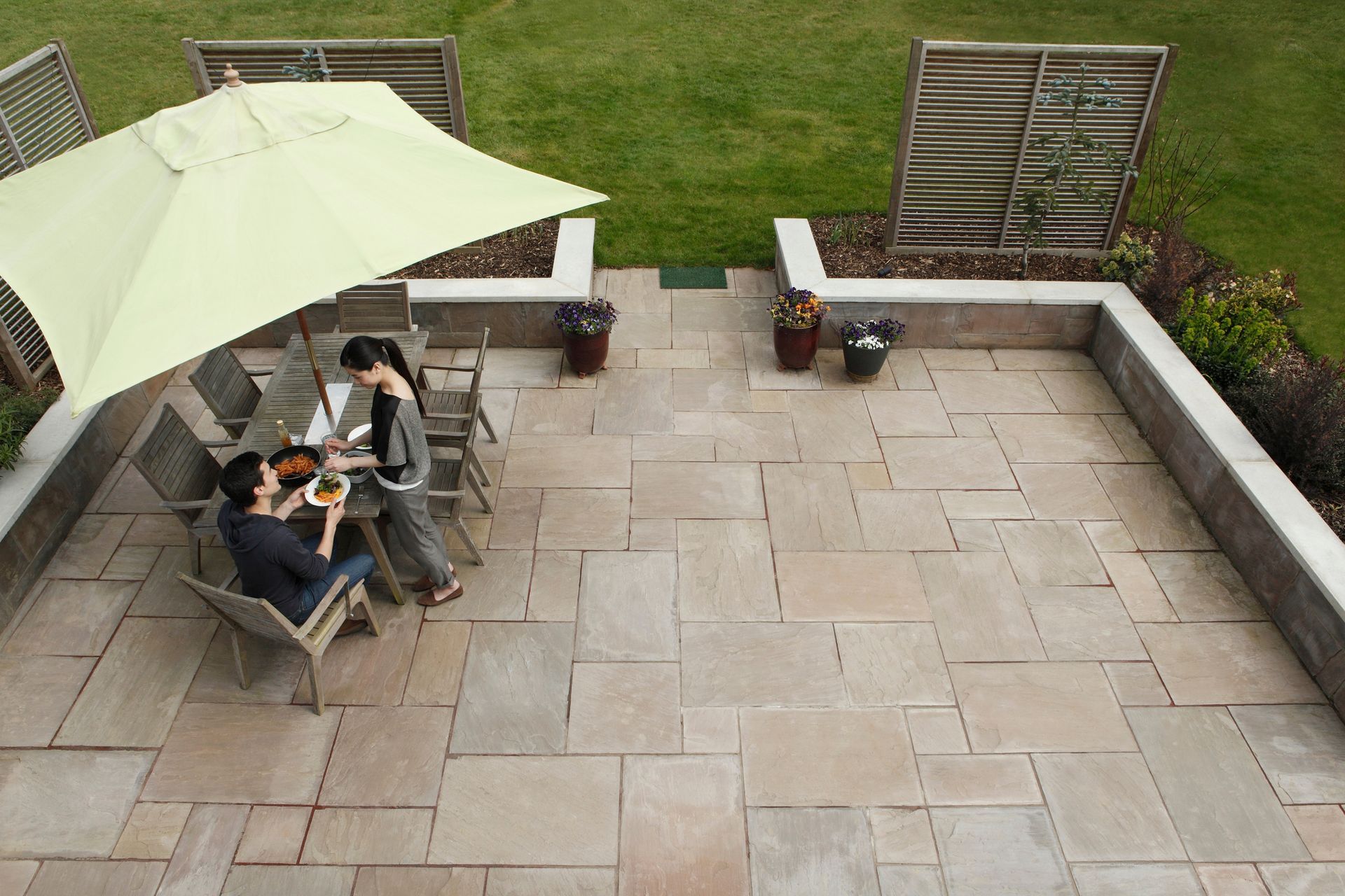 Una coppia è seduta a un tavolo sotto un ombrellone in un patio.