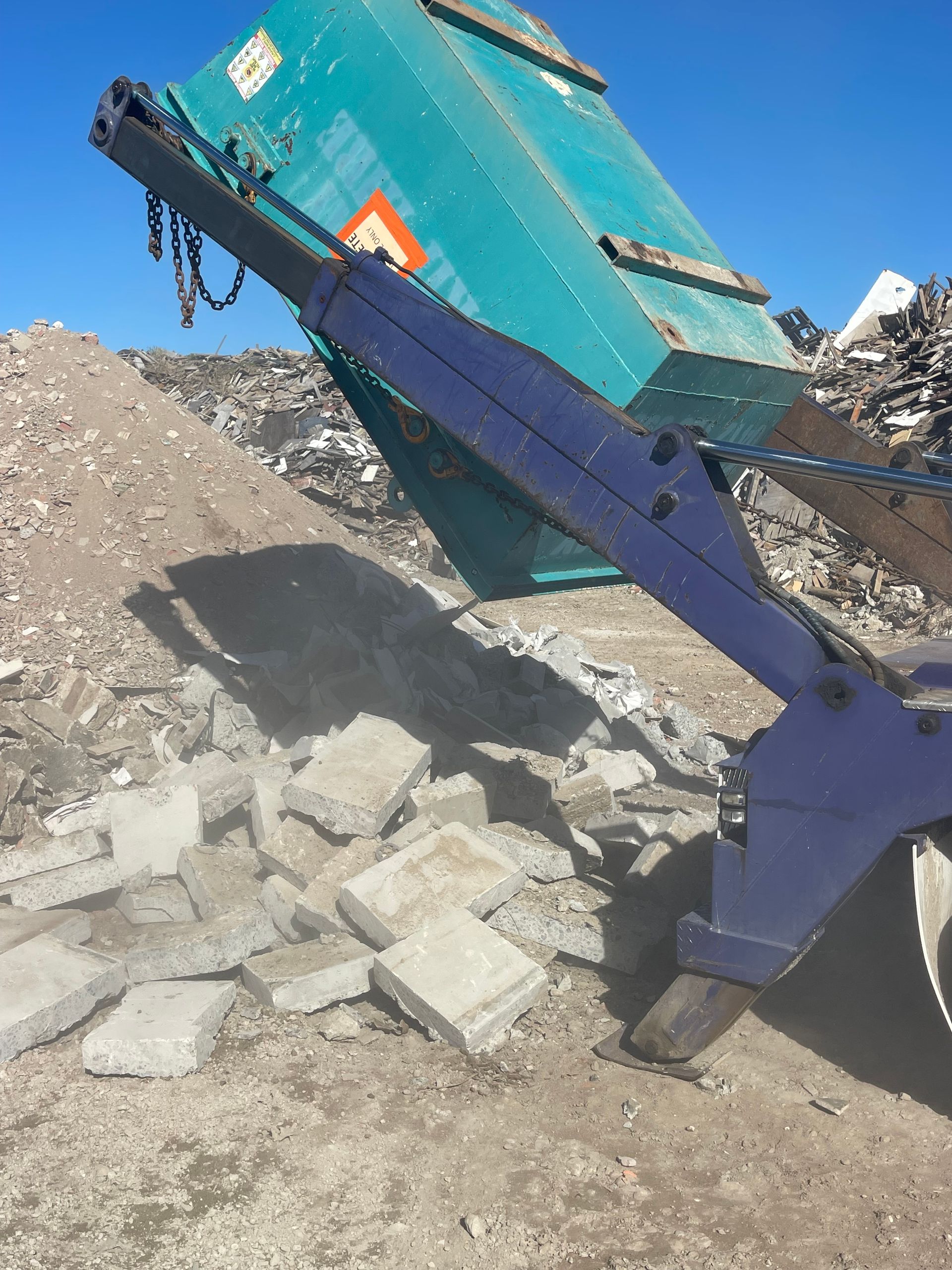 Blue Truck Lifting a Teal Dumpster to Empty Debris — Mackay Skip Hire In Andergrove, QLD