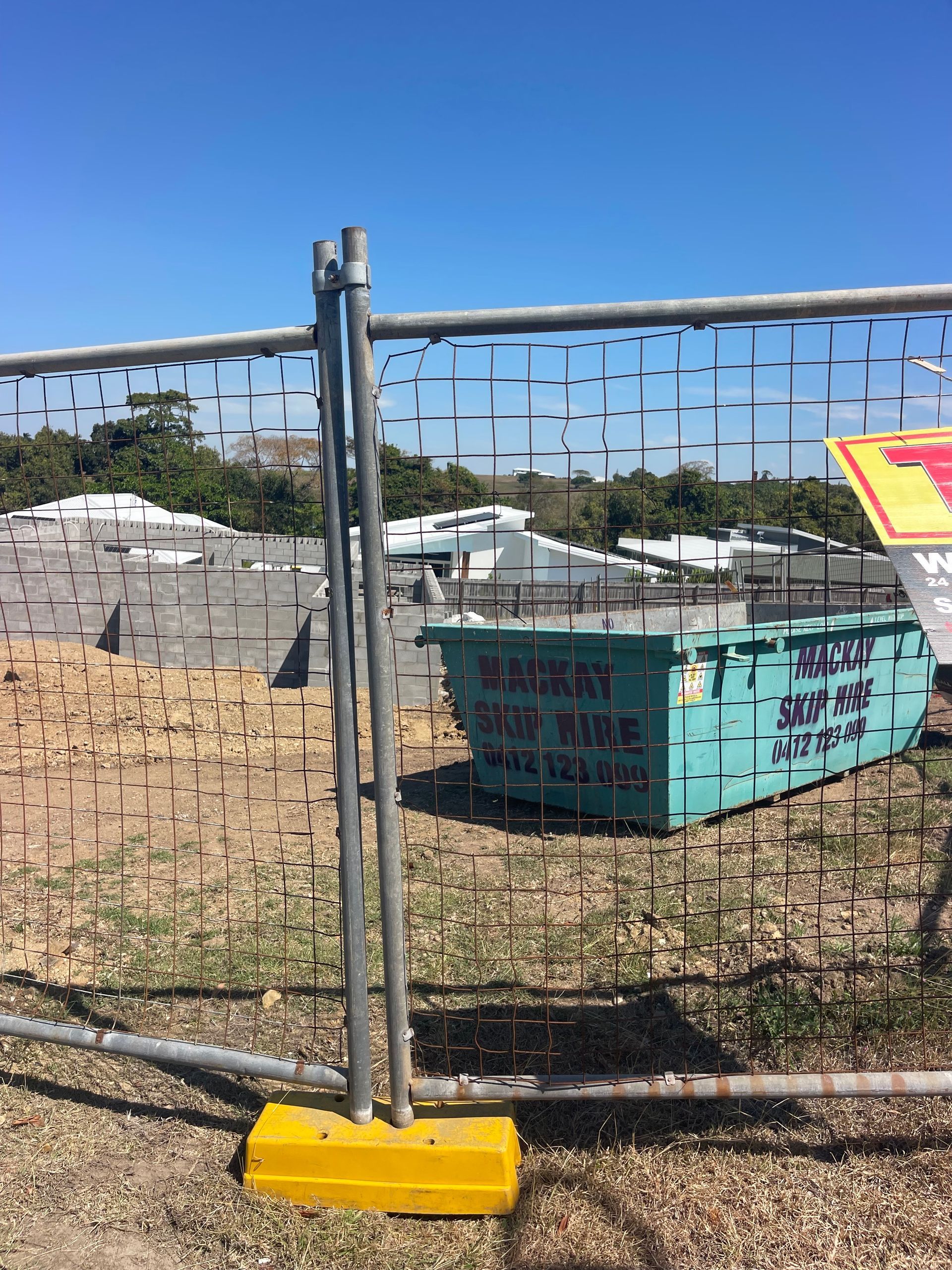 Construction Site With Temporary Fence, Blue Skip Bin — Mackay Skip Hire In Andergrove, QLD