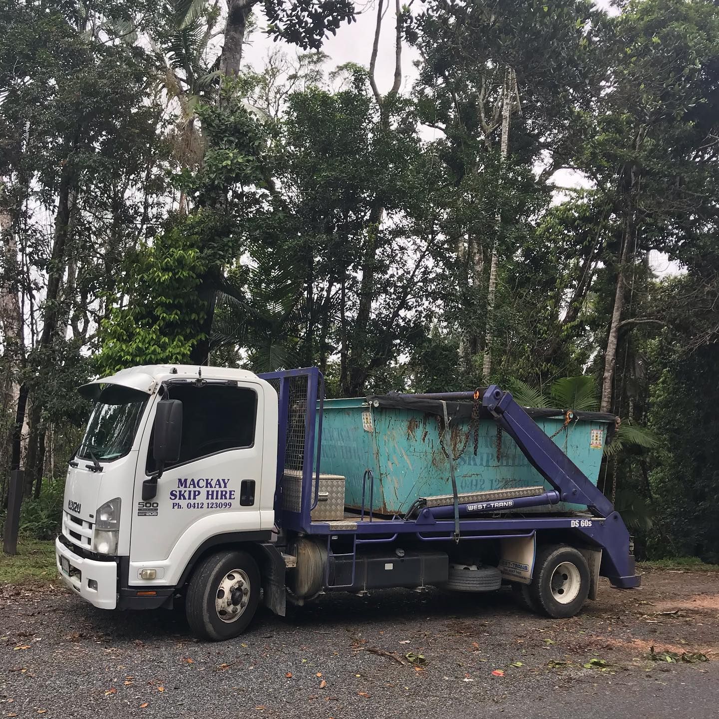 White and Blue Isuzu Dump Truck Parked on Gravel Road — Mackay Skip Hire In Andergrove, QLD