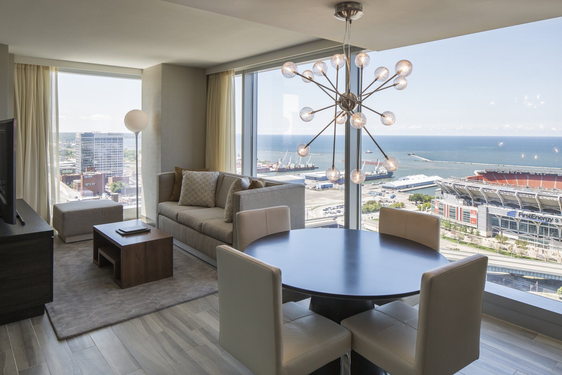 A living room with a table and chairs and a view of the ocean.