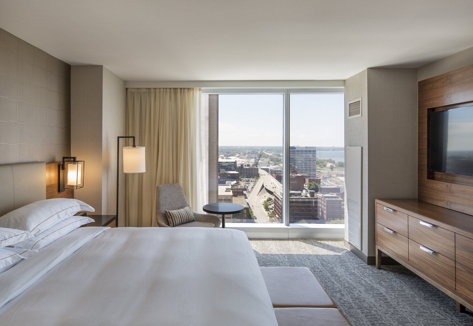 A hotel room with a large bed and a large window