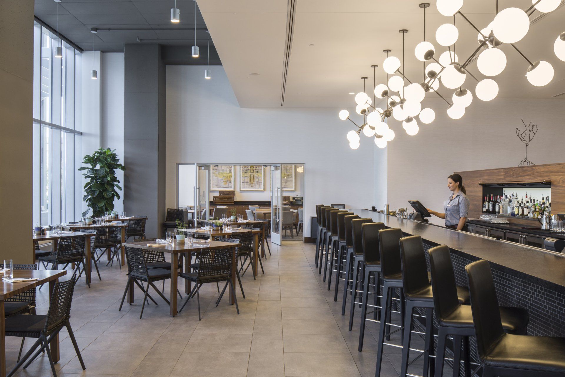 A restaurant with tables and chairs and a bar.