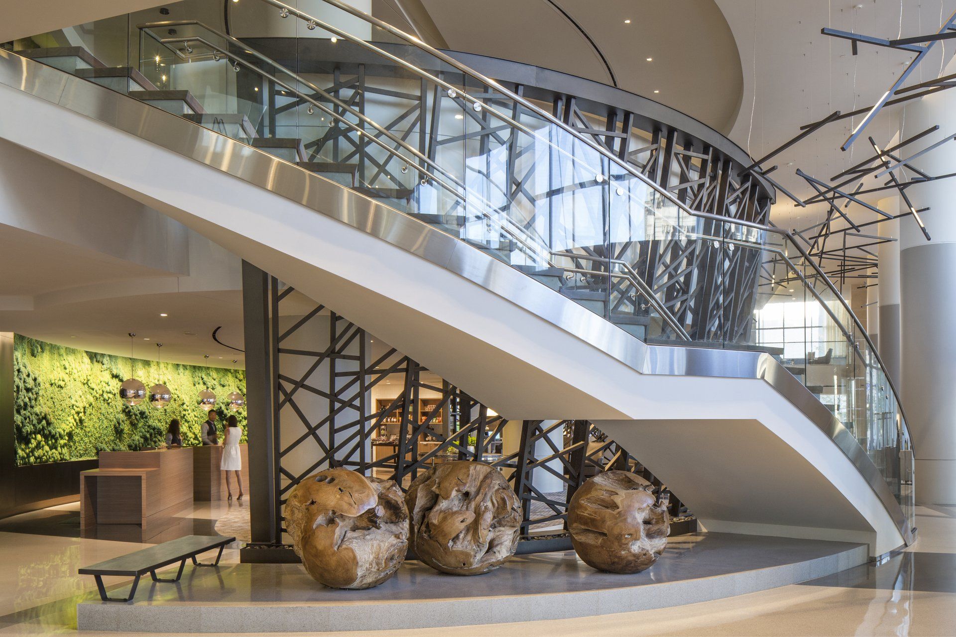 A lobby with a staircase and sculptures in front of it