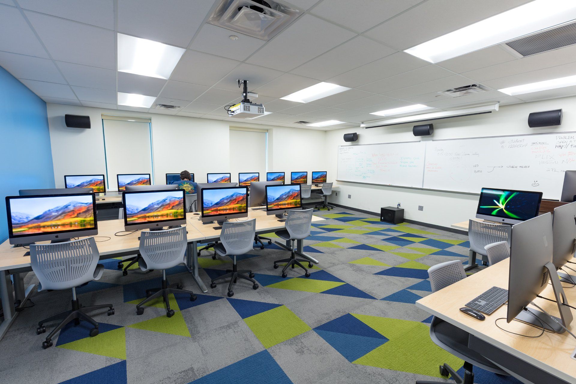 A large room filled with lots of computers and chairs.