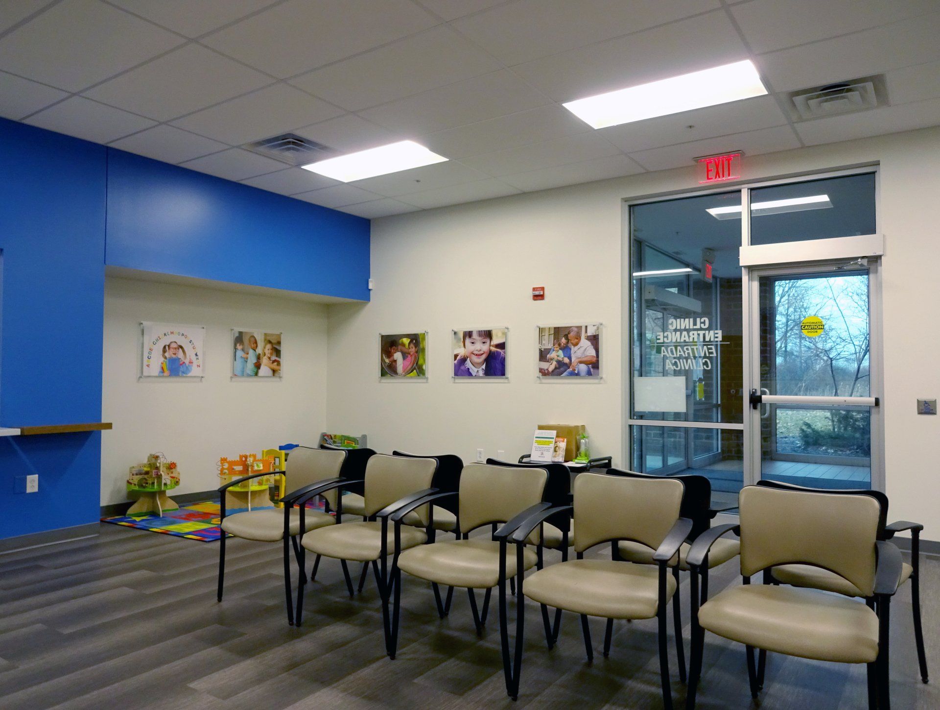 A waiting room with a lot of chairs and pictures on the wall.