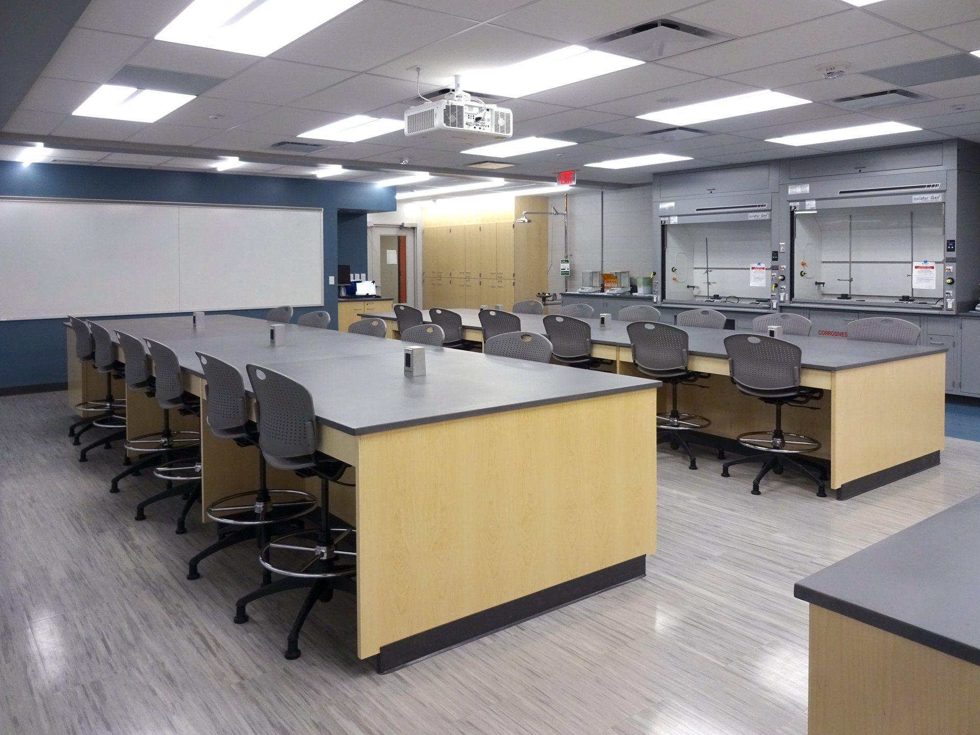 A large classroom with a projector hanging from the ceiling