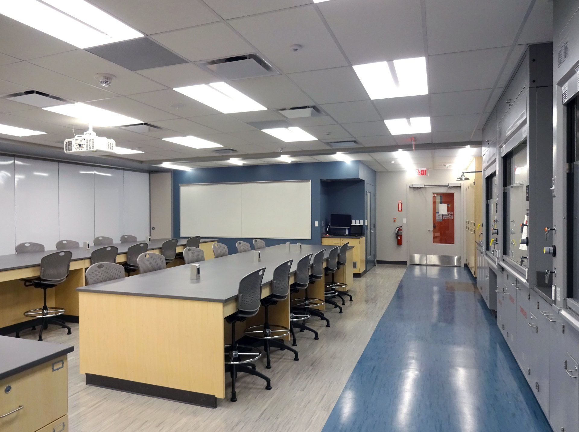 An empty classroom with a long table and chairs