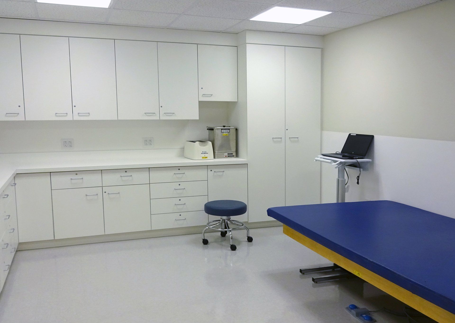 A room with white cabinets and a blue table