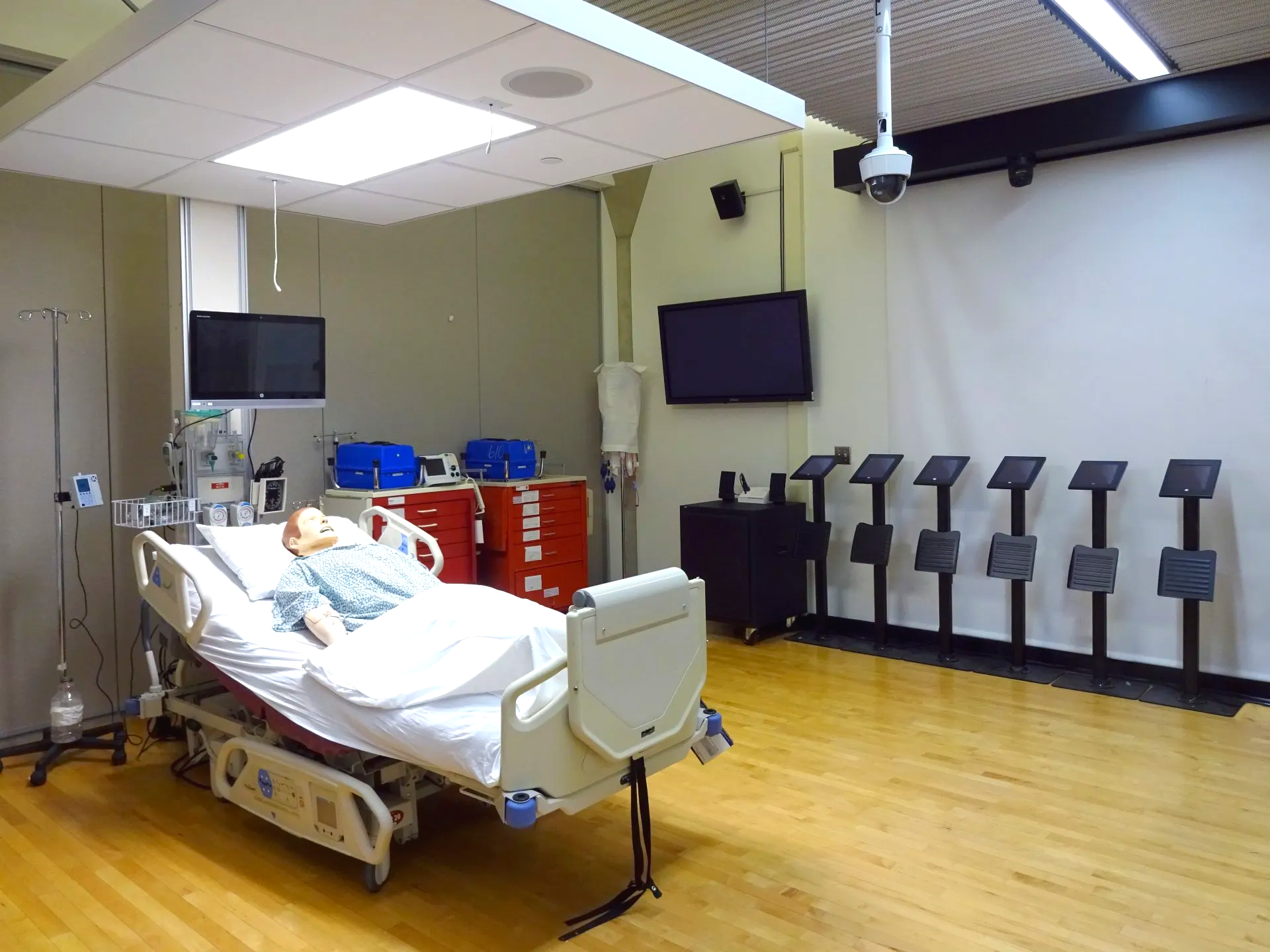 A hospital room with a bed and a monitor on the wall