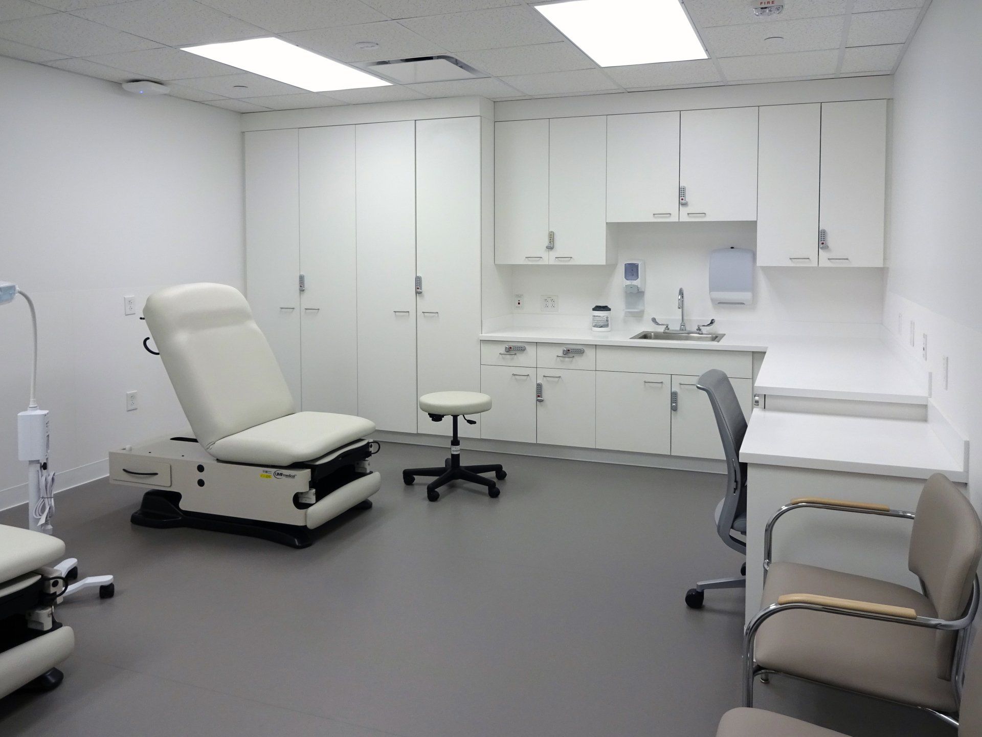 A doctor 's office with a chair and a desk
