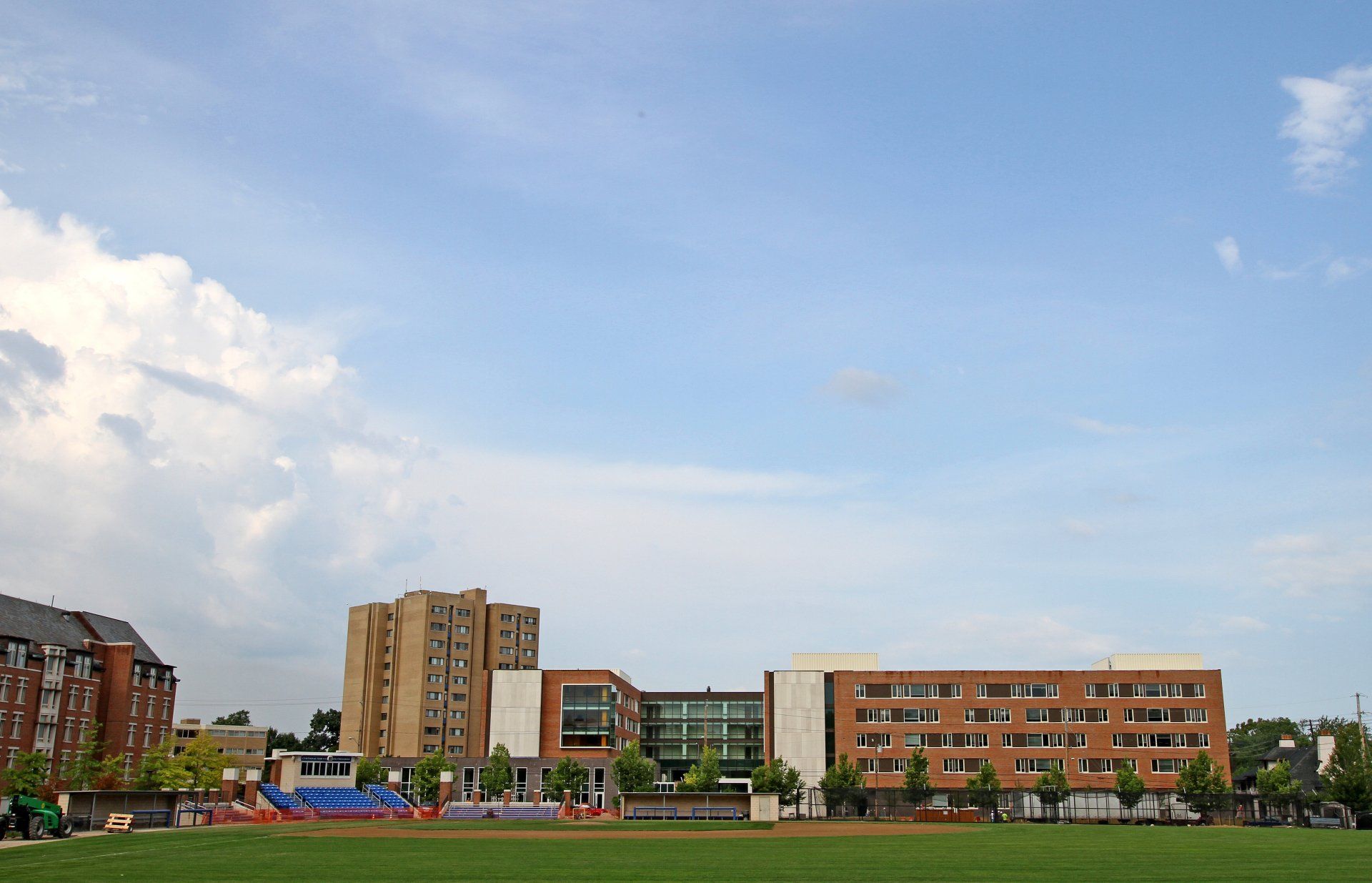 A field with buildings in the background and a blue sky