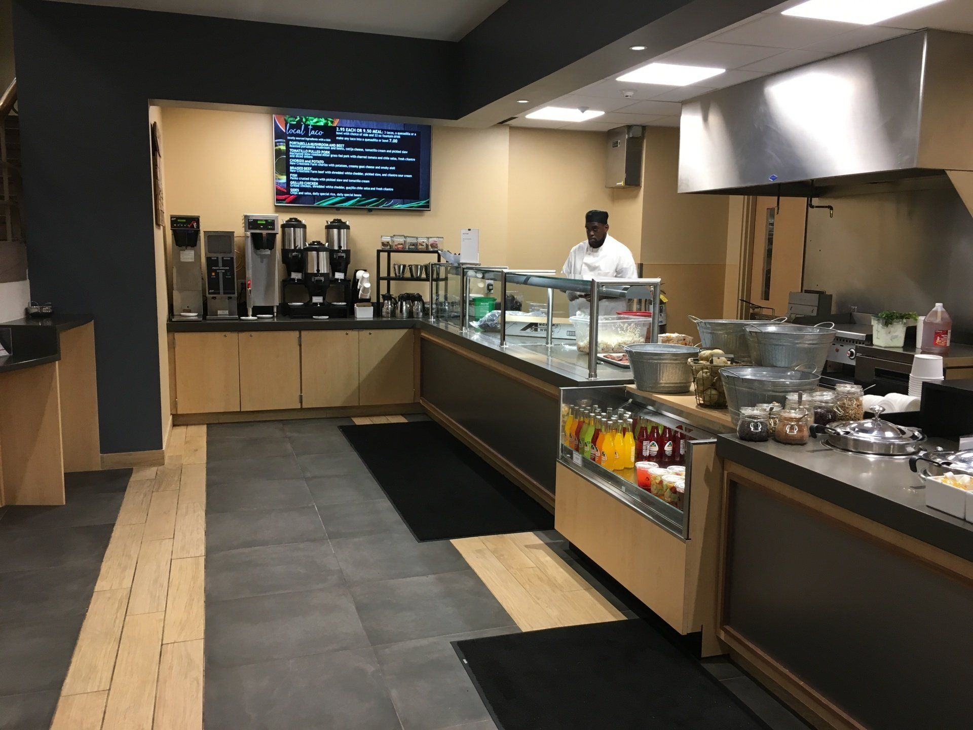 A man is standing behind a counter in a restaurant