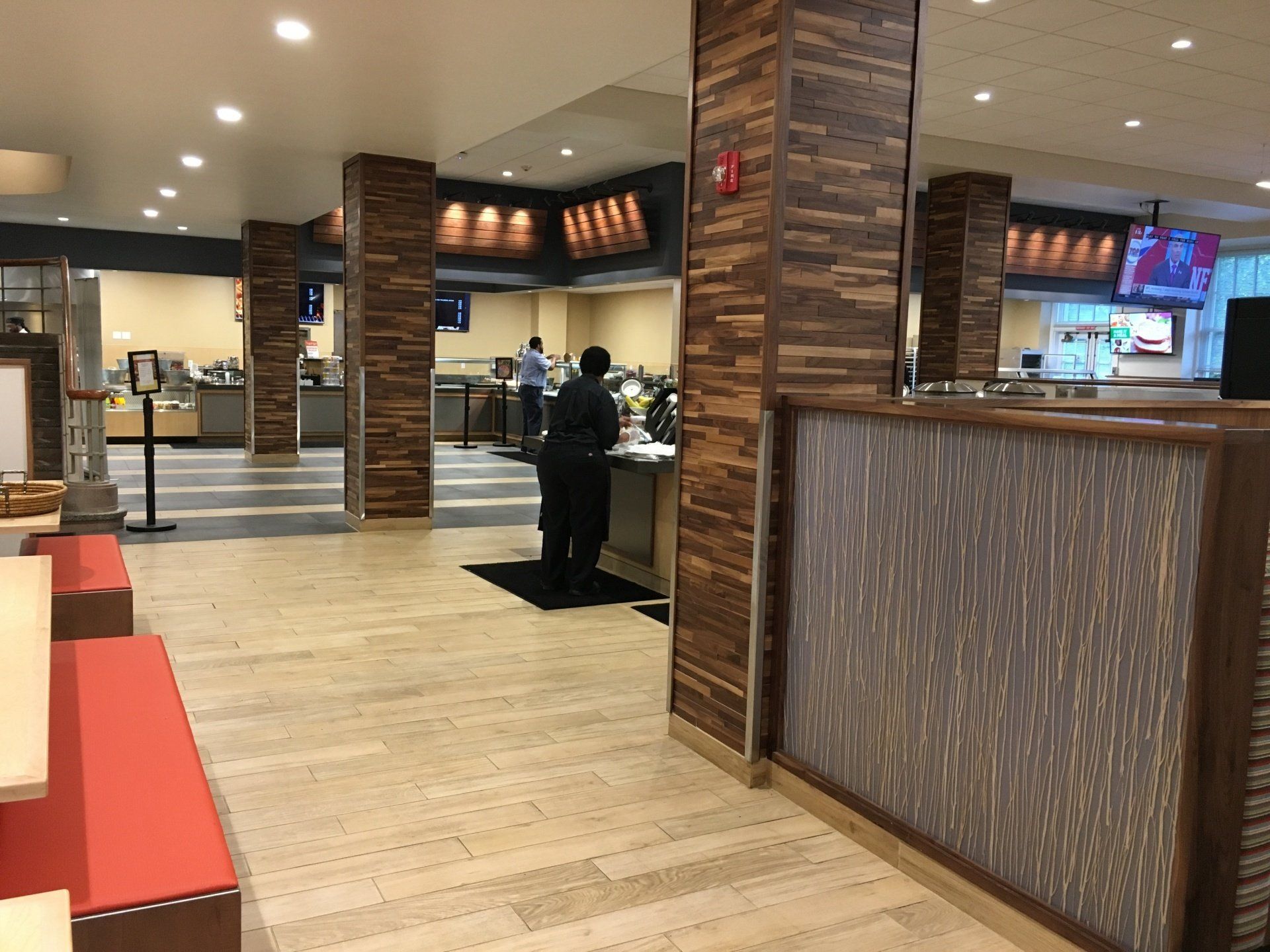 A man is standing at a counter in a restaurant.