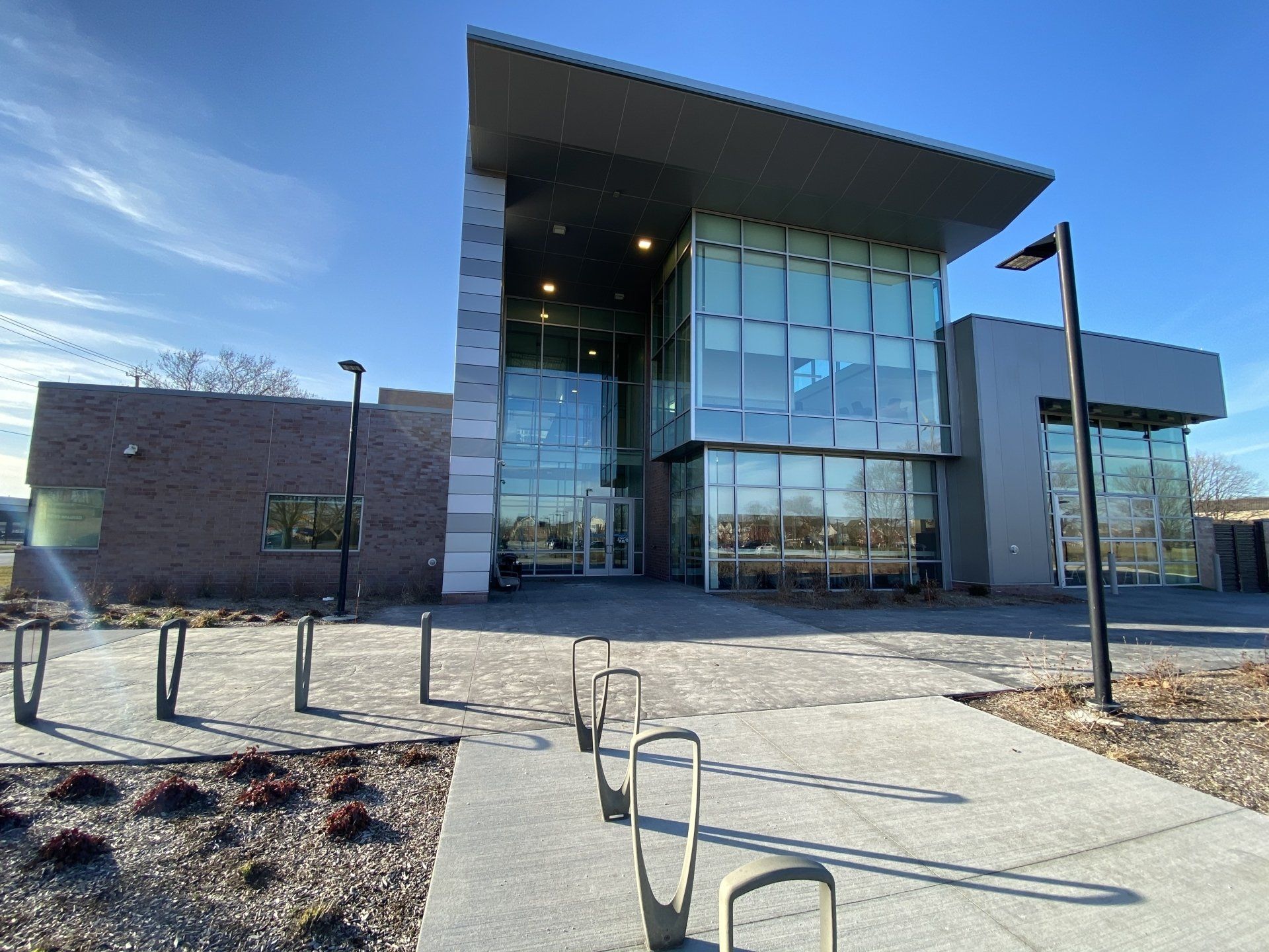 A large building with a lot of windows and a bike rack in front of it.