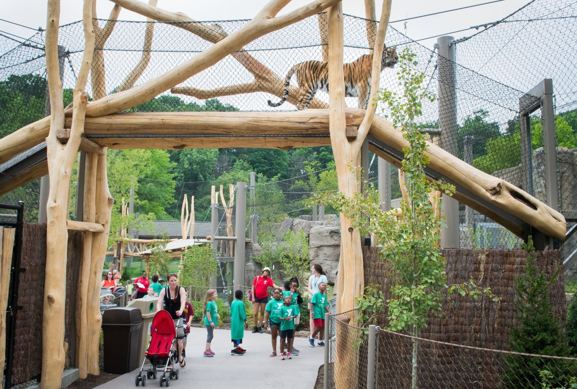 A group of people are walking through a zoo entrance.