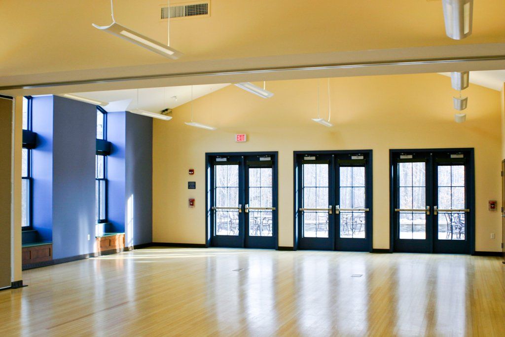 A large empty room with yellow walls and hardwood floors