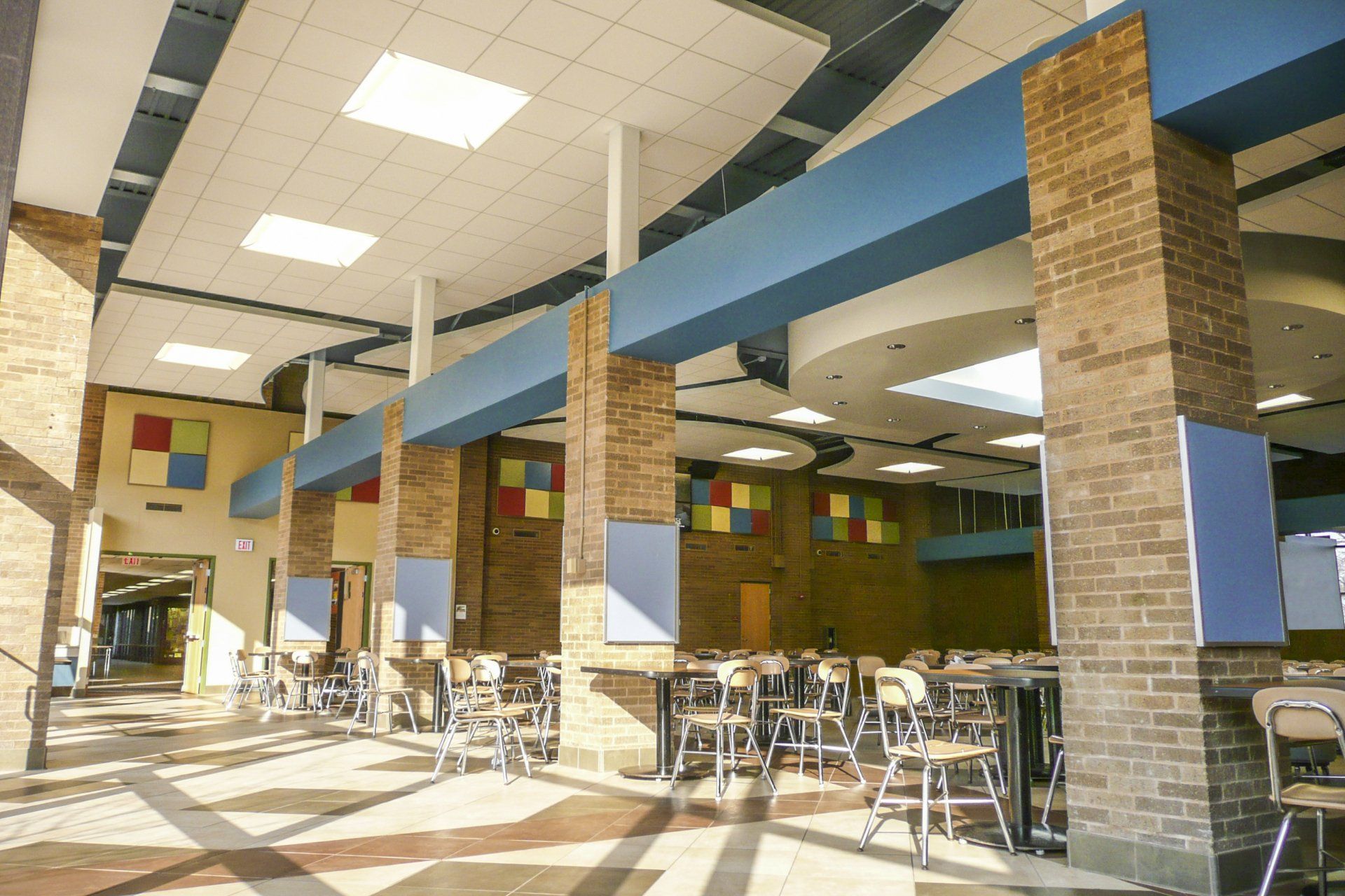A long hallway with tables and chairs in a school cafeteria
