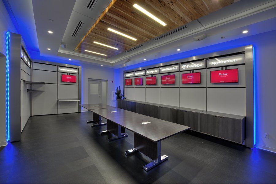 A conference room with a long table and televisions on the wall.
