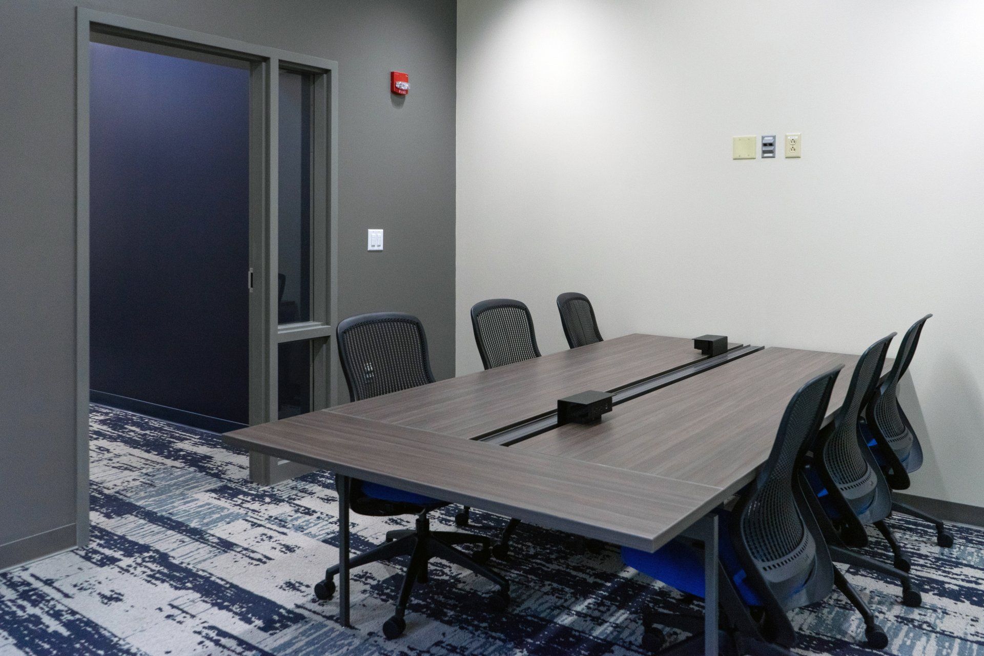 A conference room with a long table and chairs.