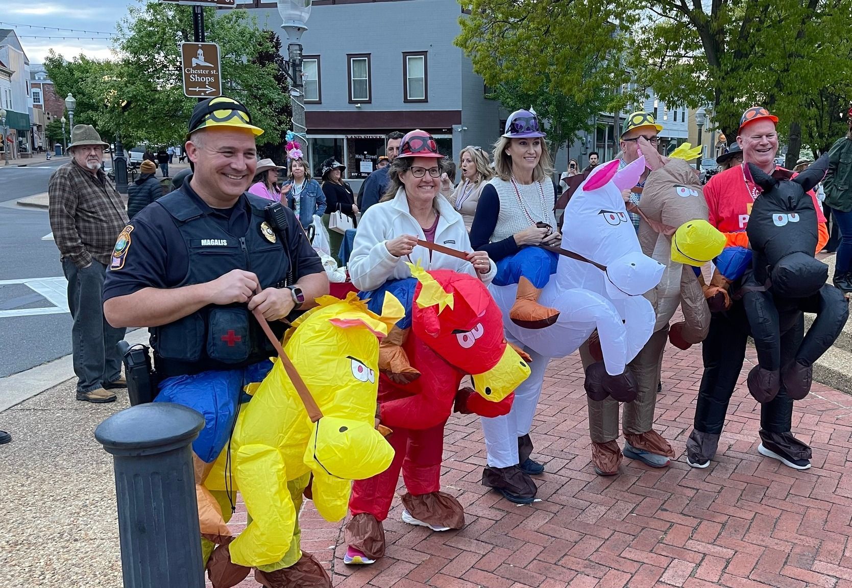 Five adults in inflatable horse costumes about to embark on a foot race for the Talk Derby to Me event.