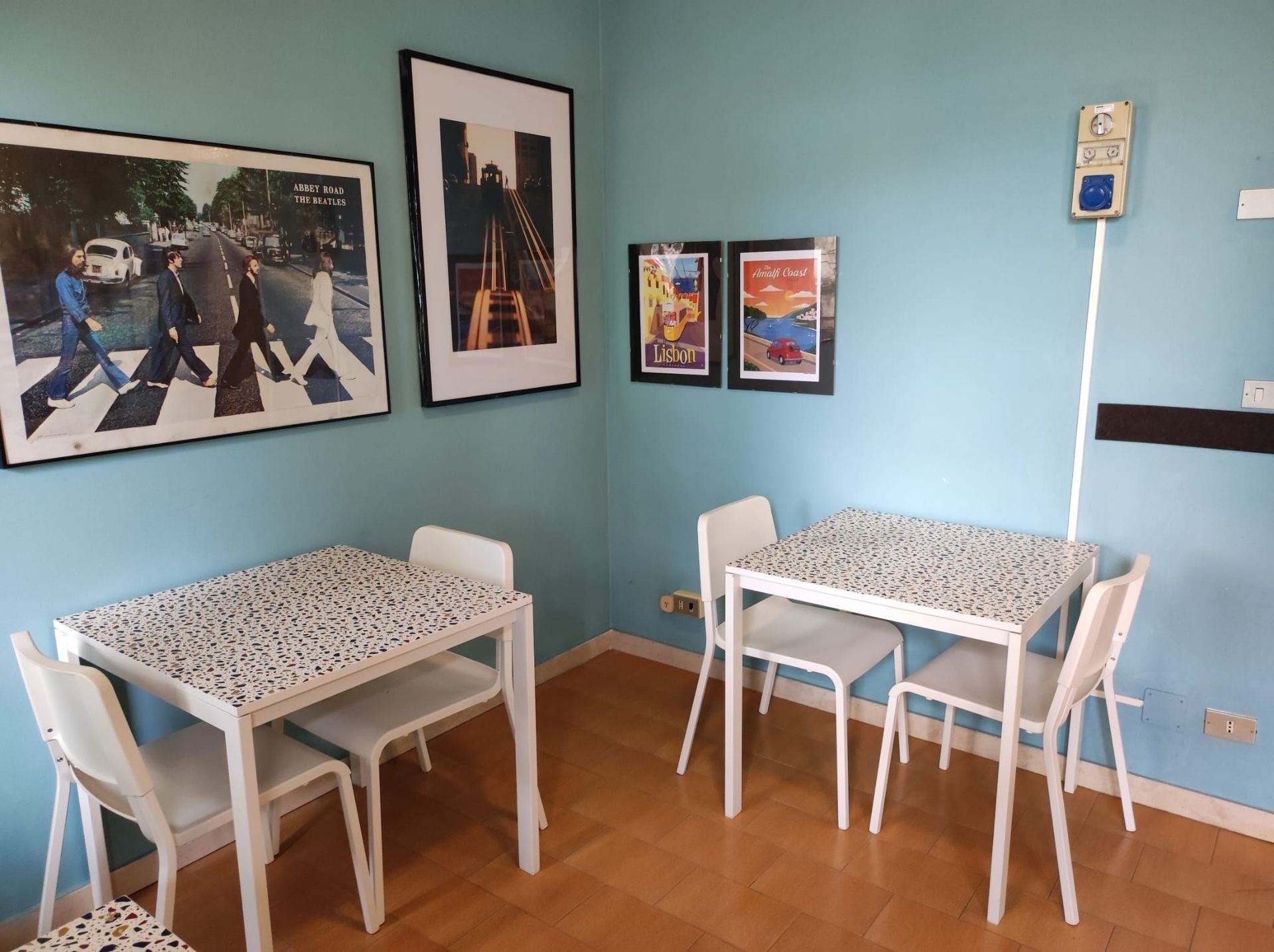 Una stanza con un tavolo e delle sedie e una foto dei Beatles sul muro