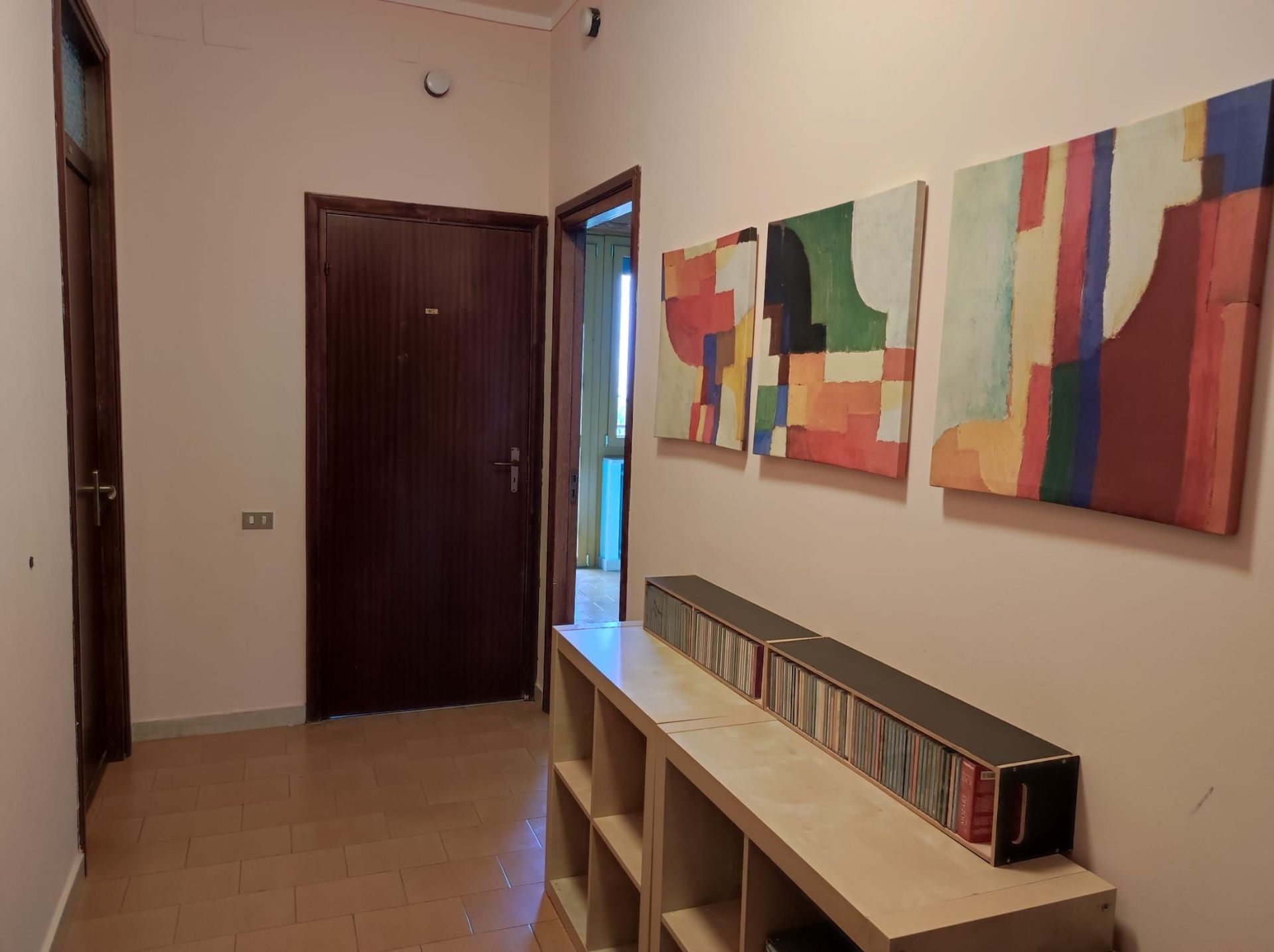 Un corridoio con uno scaffale e quadri sul muro