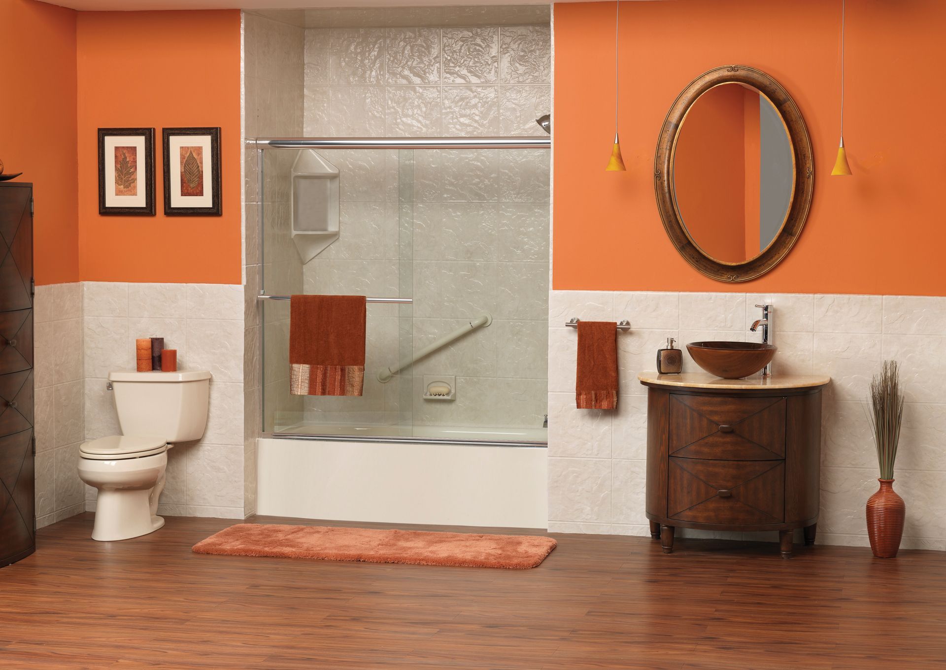 Bathroom with orange walls, white tile, wooden vanity, toilet, and shower with brown accents.