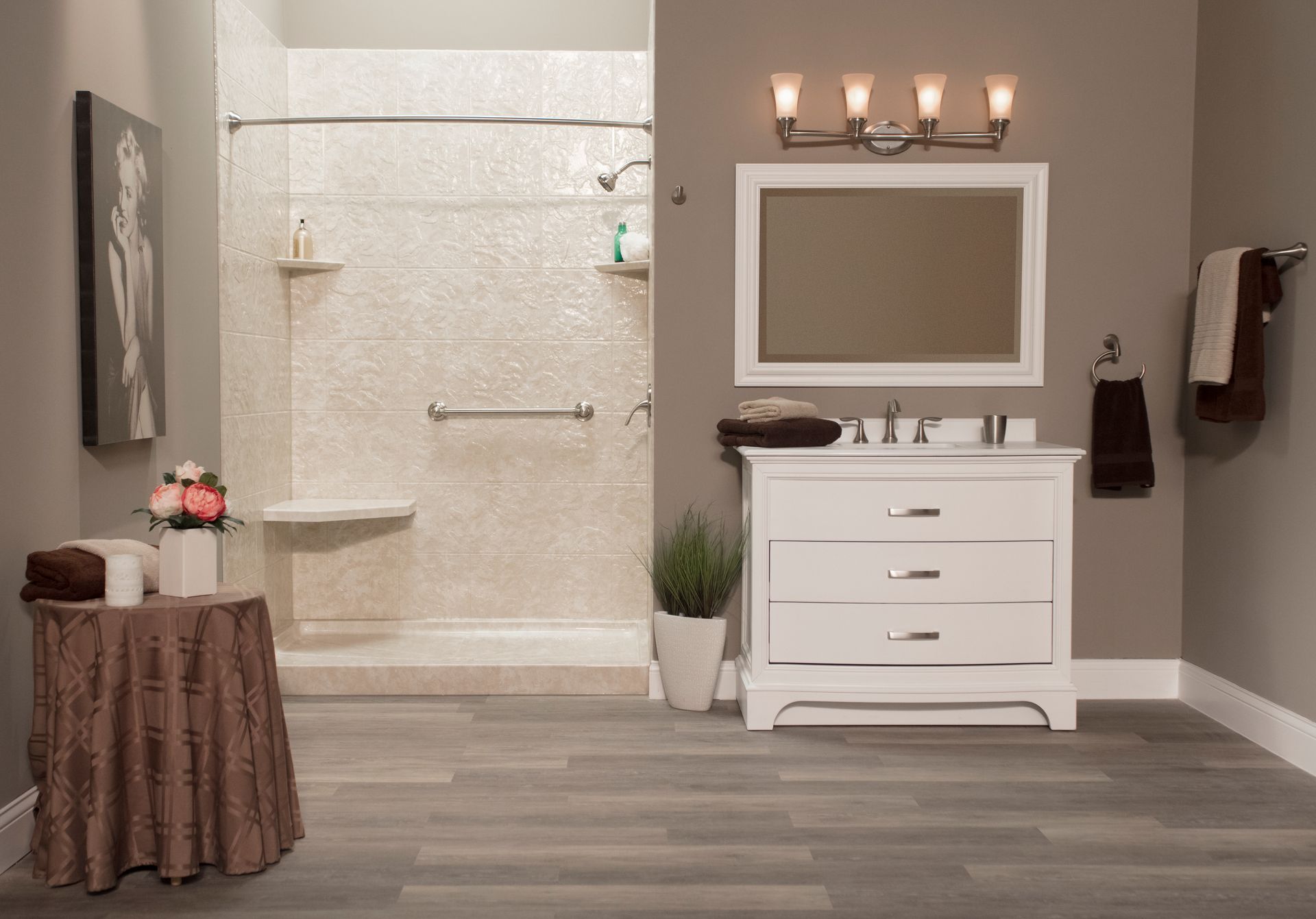 Bathroom with gray floors, shower, vanity, and accessible features like a grab bar.