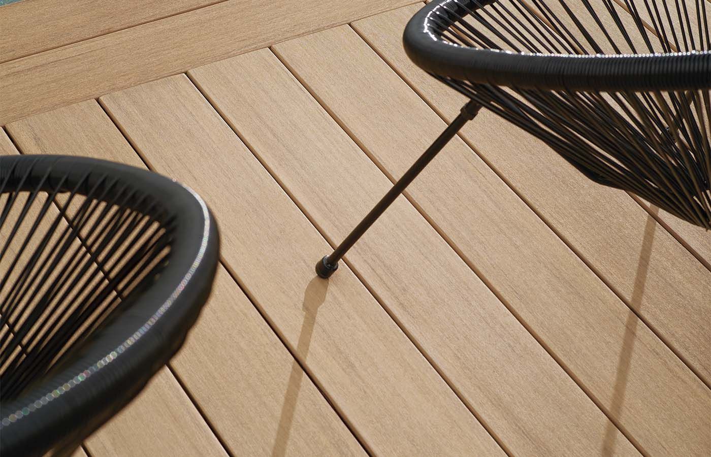 Two black wire chairs on a light brown wooden deck.