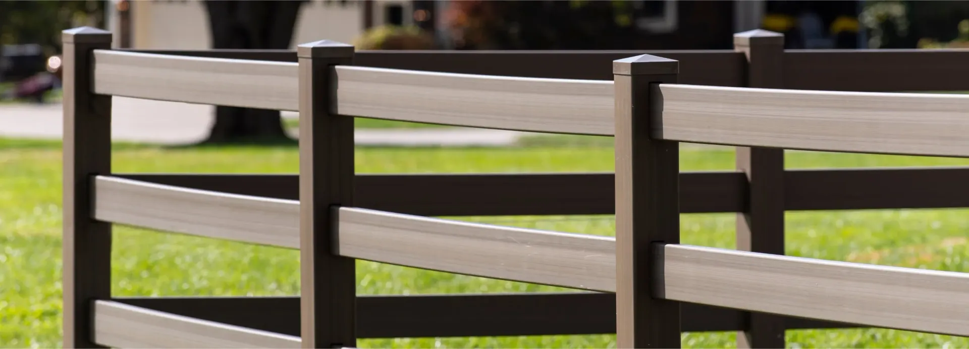 Brown and tan wooden fence in a grassy yard.