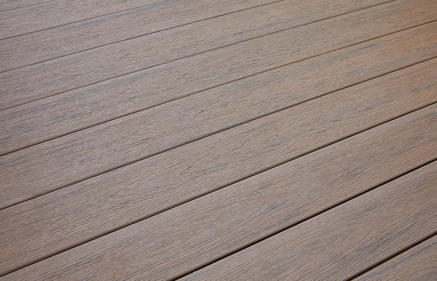 Close-up of weathered, light-brown wooden deck planks with textured surface and visible gaps.