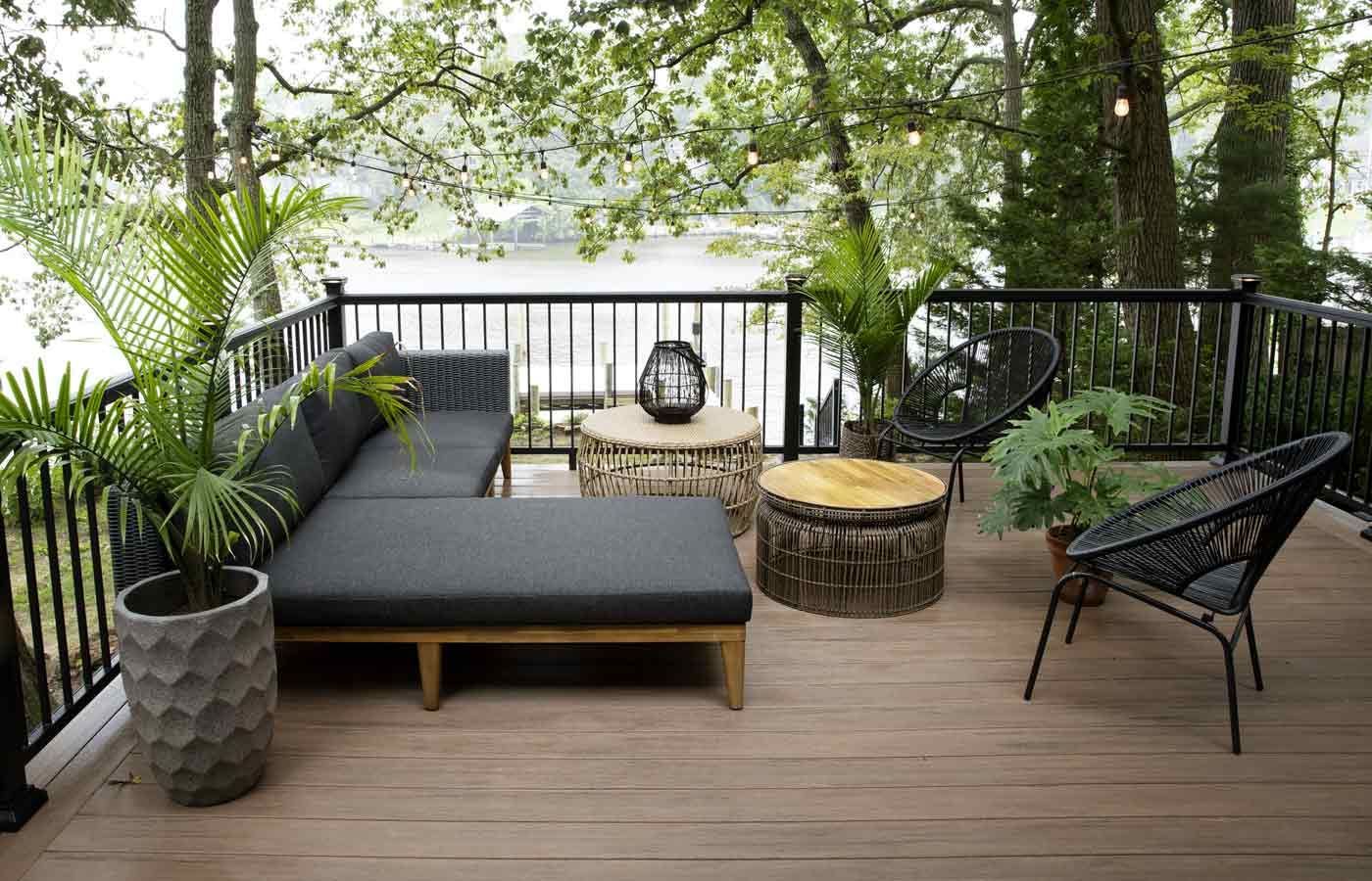 Deck overlooking lake with modern outdoor furniture.