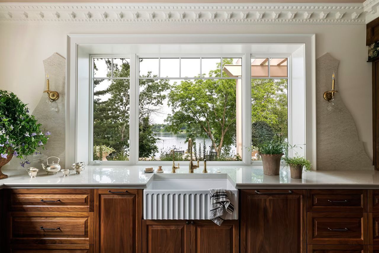 Kitchen with white sink, dark wood cabinets, and a window overlooking a lake.