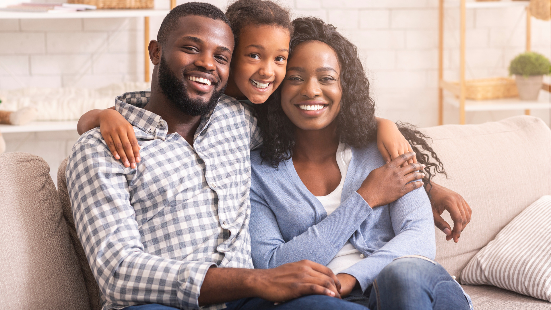 A family is posing for a picture while sitting on a couch.