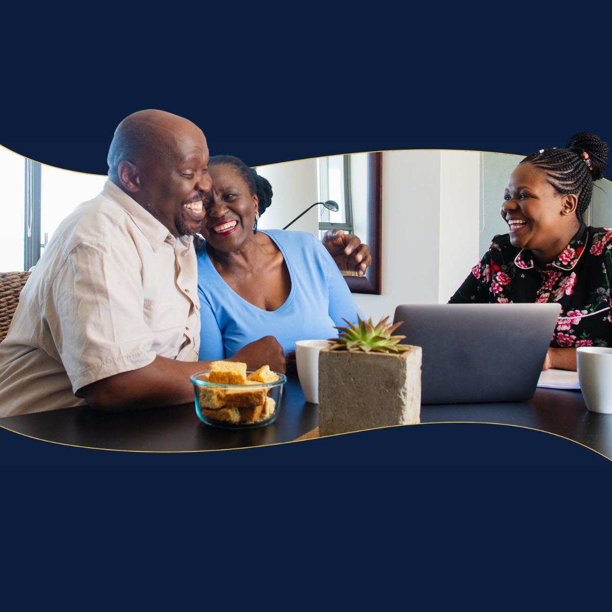 A man and two women are sitting at a table with a laptop