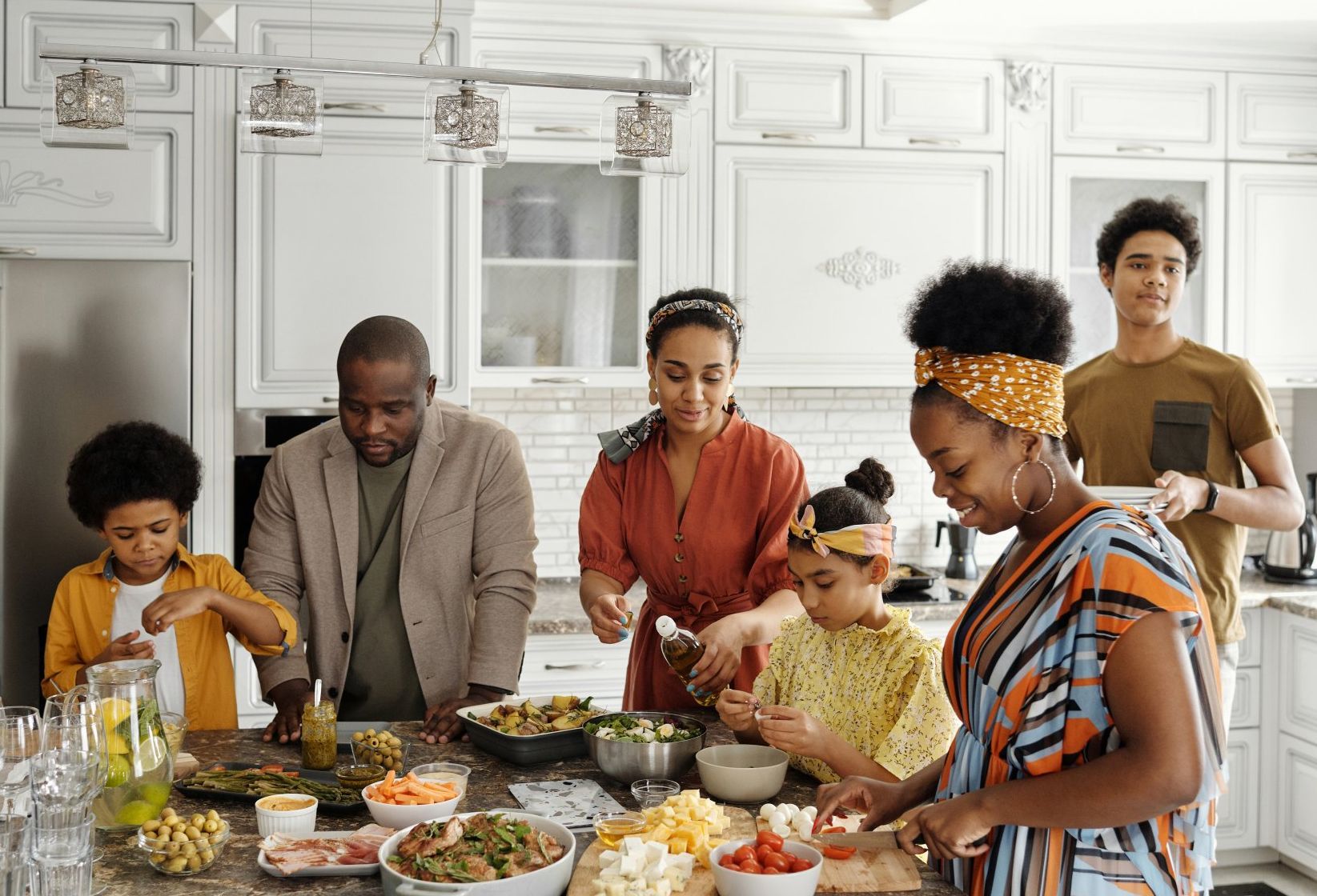 A family is preparing food together in a kitchen.