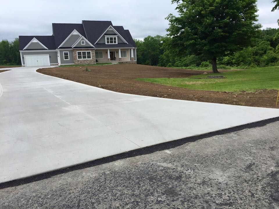 A large house with a concrete driveway leading to it
