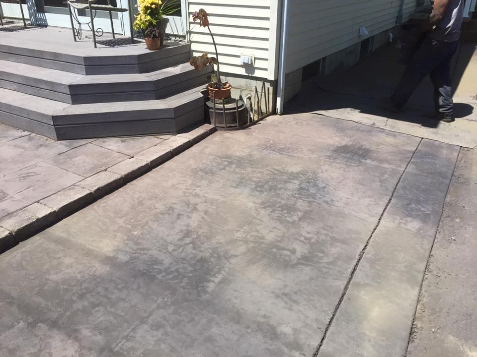 A concrete patio with stairs leading up to a house.