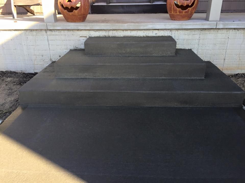 There are two pumpkins on the porch of a house.