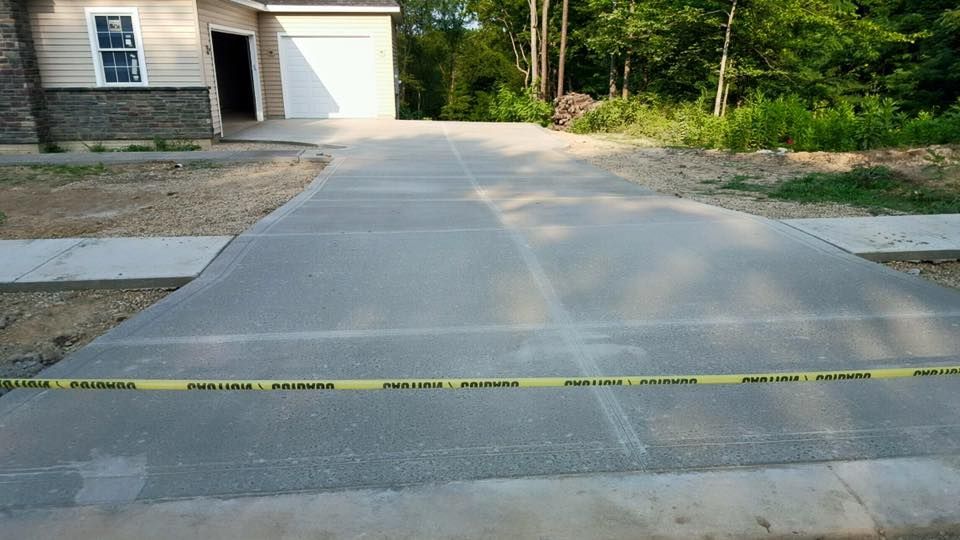 A concrete driveway is being built in front of a house.