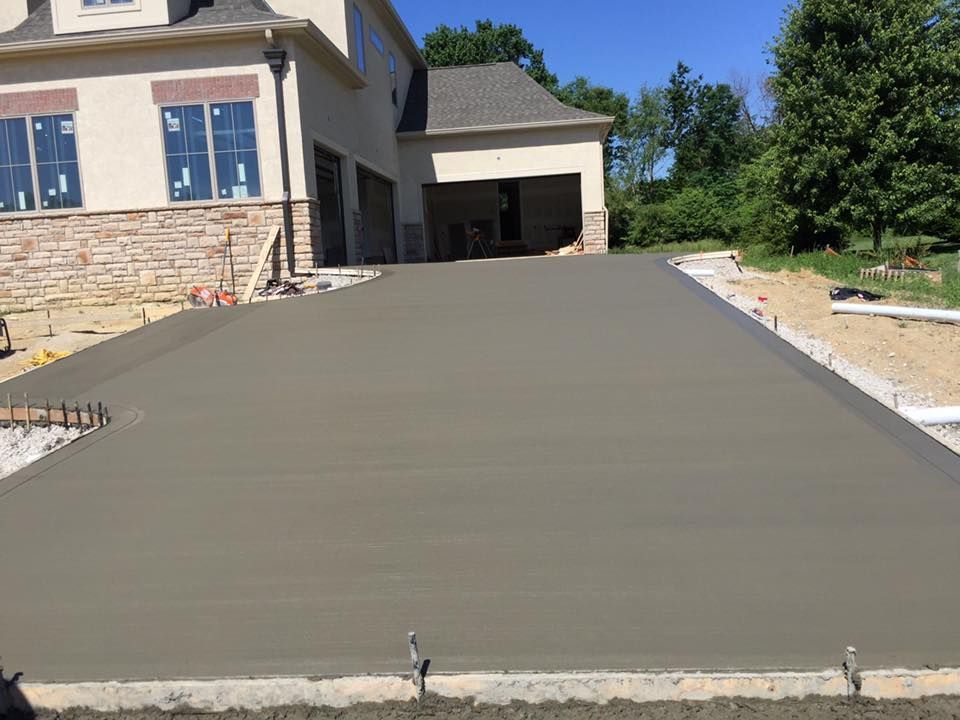 A concrete driveway is being built in front of a house.